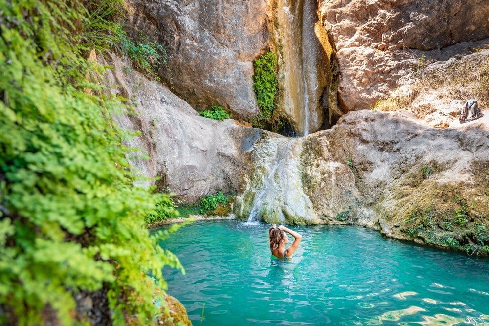 Young Happy Woman Swimming In Turquoise Blue Crystal Clear Water