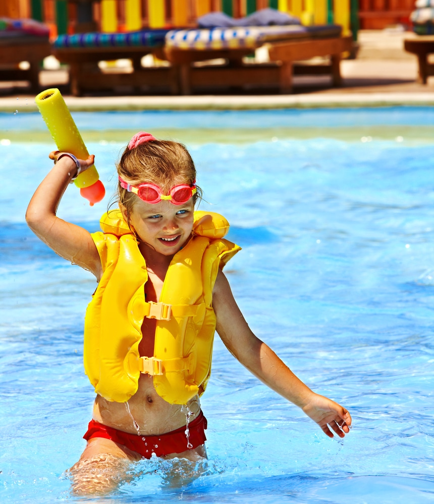 Happy Child Playing In Swimming Pool wearing Swimming Vest